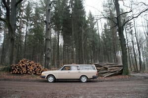 Alter Volvo vor Holzstapel